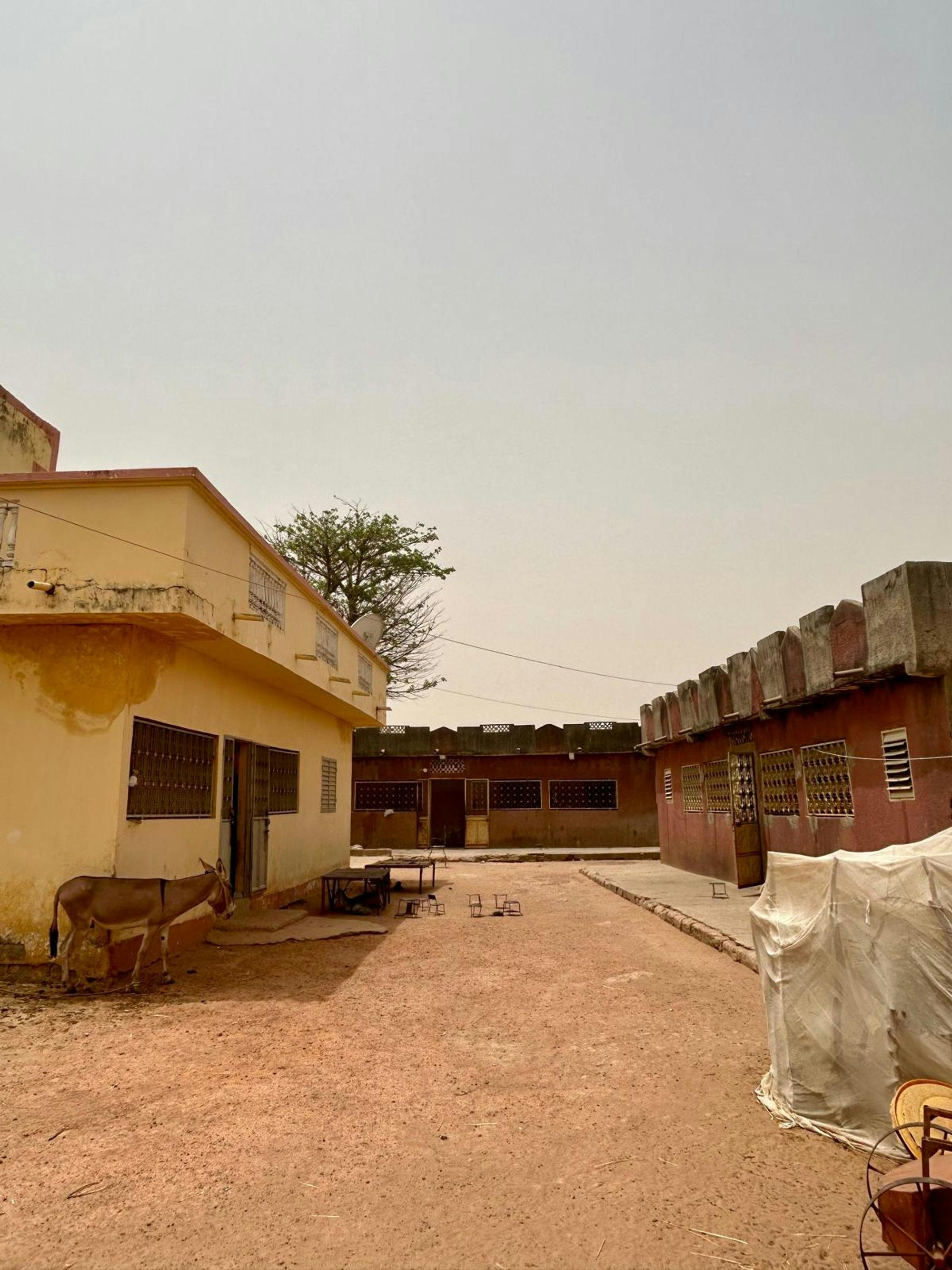 A Household Chosen for Sensor Installation: Grid-connected households located closest to the transformer are approached for sensor installation. In the Kaolack region, family compounds are the predominant form of housing. In the photo above, the sensor was installed in the home of the leader of the compound (yellow building). 